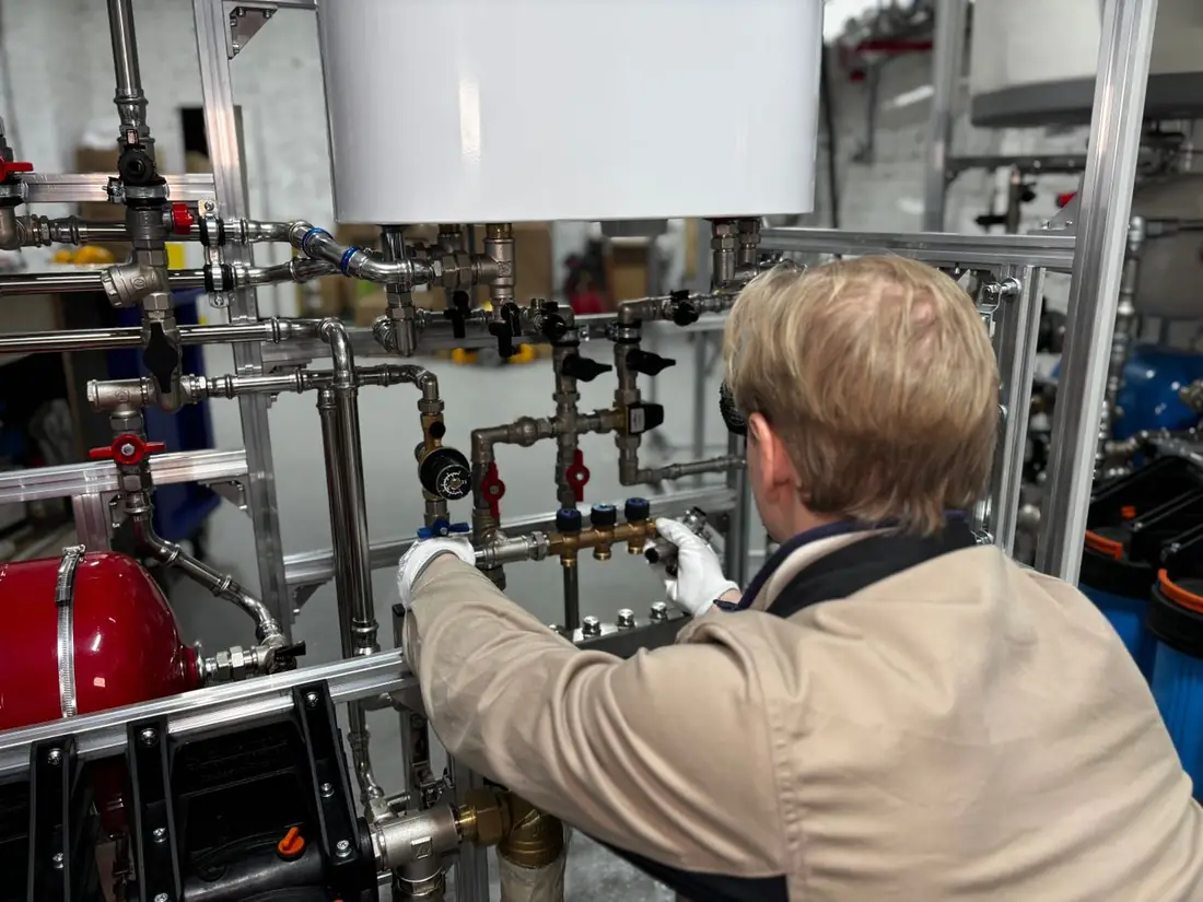 Profissional ajustando tubulação de um equipamento industrial