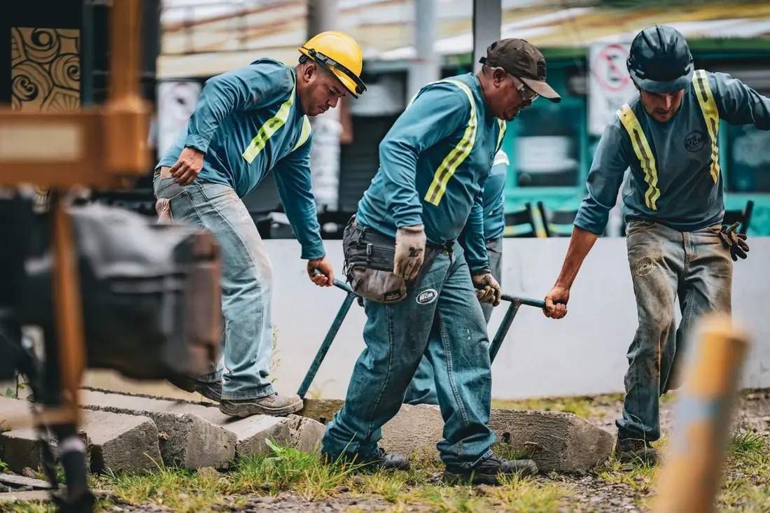 Equipe assentando piso intertravado em área externa